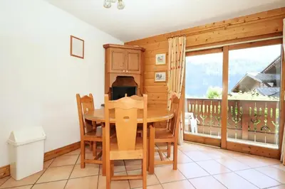 a dining room with a table and a balcony at Résidence Les Hauts De Chavants - Hauts de Chavants Bellachat 1 MAE-7730 in Les Houches