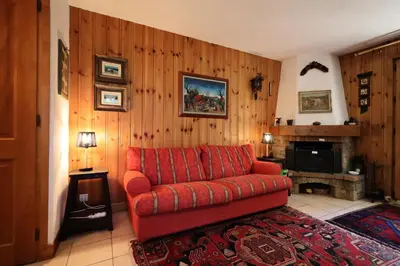 a living room with a red couch and a fireplace at Résidence Les Eaux Rousses - Les Eaux Rousses MAE-9964 in Les Houches