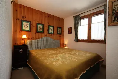 a bedroom with a bed in a room with wooden walls at Résidence Les Eaux Rousses - Les Eaux Rousses MAE-9964 in Les Houches