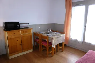a small dining room table with chairs and a television at Résidence Le Royal - Royal 12 MAE-9034 in Combloux