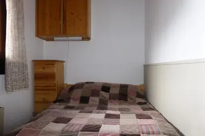 a bedroom with a bed and a wooden cabinet at Résidence Le Royal - Royal 12 MAE-9034 in Combloux