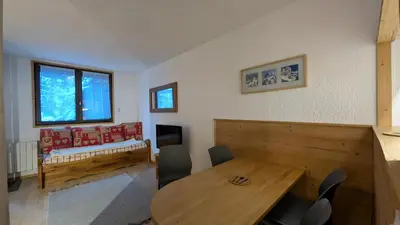 a living room with a wooden table and chairs at L'alpage in Chamonix-Mont-Blanc