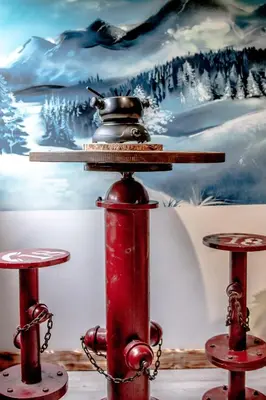 a red fire hydrant in front of a painting at Le Tête Pied Centre/Télécabine Saint-Gervais in Saint-Gervais-les-Bains