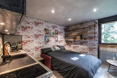a bedroom with a bed and a brick wall at Le Tête Pied Centre/Télécabine Saint-Gervais in Saint-Gervais-les-Bains