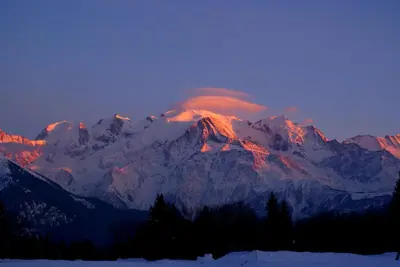 a mountain covered in snow with a sunset at Le Tête Pied Centre/Télécabine Saint-Gervais in Saint-Gervais-les-Bains
