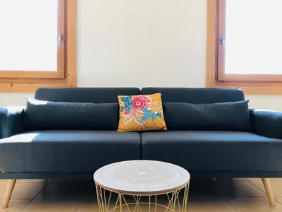a blue couch with a yellow pillow and a coffee table at Chalet Cosy in Saint-Gervais-les-Bains