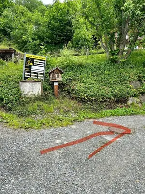a road with a red arrow on the ground next to a sign at Chalet Cosy in Saint-Gervais-les-Bains