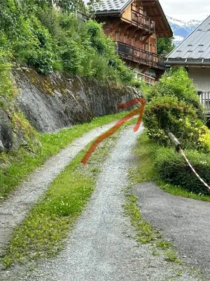 a dirt road next to a house with an orange ribbon at Chalet Cosy in Saint-Gervais-les-Bains
