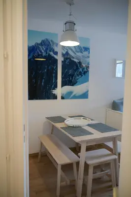 a dining room with a table and a painting at Appartement Cosy - Aiguille du Midi in Chamonix-Mont-Blanc