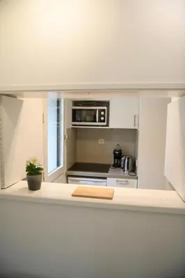 a kitchen with white cabinets and a stove top oven at Appartement Cosy - Aiguille du Midi in Chamonix-Mont-Blanc