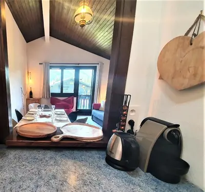 a room with a wooden table and a couch at Chamonix - superbe appartement vue Mont Blanc in Chamonix-Mont-Blanc