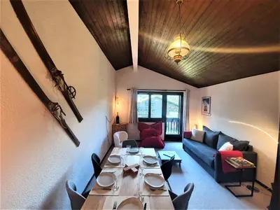 a living room with a long table and a couch at Chamonix - superbe appartement vue Mont Blanc in Chamonix-Mont-Blanc