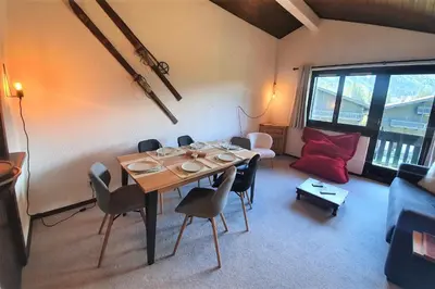 a dining room with a table and chairs and a couch at Chamonix - superbe appartement vue Mont Blanc in Chamonix-Mont-Blanc