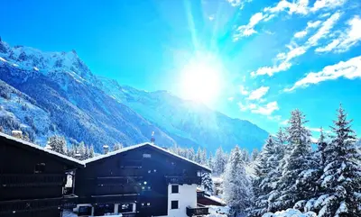 a snow covered mountain with the sun in the sky at Chamonix - superbe appartement vue Mont Blanc in Chamonix-Mont-Blanc