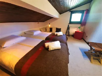 a bedroom with two beds and a window at Chamonix - superbe appartement vue Mont Blanc in Chamonix-Mont-Blanc