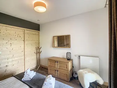 a bedroom with a bed and a dresser and a window at Demi-chalet de luxe avec piscine et vue Mont Blanc - FR-1-560-71 in Combloux