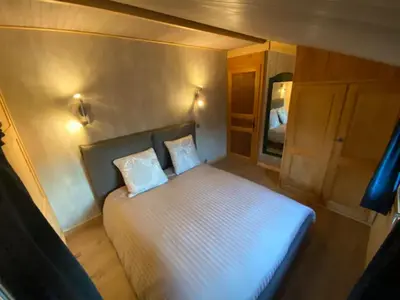 a small bedroom with a white bed with two pillows at Le Battieu in Samoëns