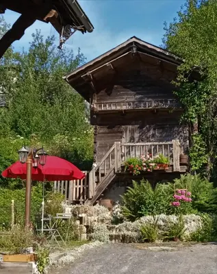 a log cabin with a porch and an umbrella at Le Battieu in Samoëns