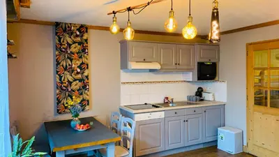 a kitchen with white cabinets and a sink and a table at Appartement vue Montblanc 5mn piste1 in Les Houches