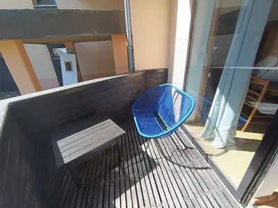 a blue chair and a bench on a balcony at Duplex Argentière, 50m2, 6 pers, idéalement placé in Chamonix-Mont-Blanc