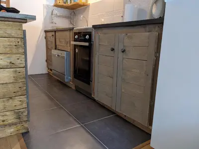 a kitchen with wooden cabinets and a stove at Duplex Argentière, 50m2, 6 pers, idéalement placé in Chamonix-Mont-Blanc