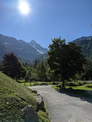 a road with a tree and mountains in the background at Duplex Argentière, 50m2, 6 pers, idéalement placé in Chamonix-Mont-Blanc
