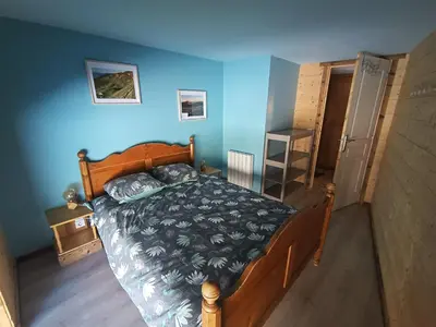 a bedroom with a bed and a blue wall at Duplex Argentière, 50m2, 6 pers, idéalement placé in Chamonix-Mont-Blanc