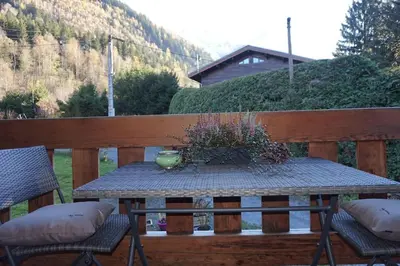 a table with a vase on it on a deck at Appartement La Suite Mont-Blanc in Chamonix-Mont-Blanc