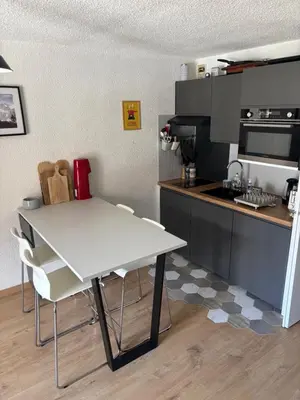 a small kitchen with a white table and chairs at Location studio plein centre Les Carroz in Les Carroz d'Araches