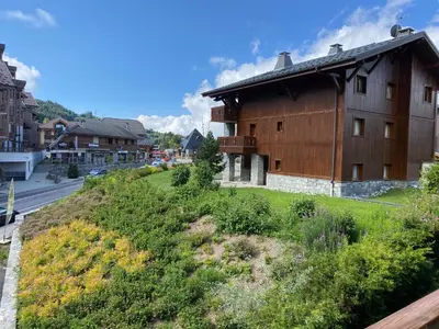 a house on a hill next to a street at Location studio plein centre Les Carroz in Les Carroz d'Araches