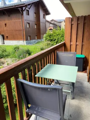 a table and two chairs on a balcony at Location studio plein centre Les Carroz in Les Carroz d'Araches