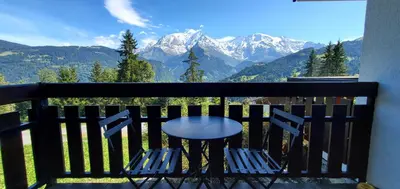 a table and chairs on a balcony with mountains at Appartement Saint Gervais les Bains vue imprenable Mont Blanc in Saint-Gervais-les-Bains