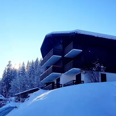 a building in the snow with a pile of snow at Appartement Saint Gervais les Bains vue imprenable Mont Blanc in Saint-Gervais-les-Bains