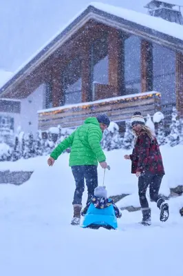 two people playing with a child in the snow at Chalet Rytola, modern & central chalet in Chamonix in Chamonix-Mont-Blanc