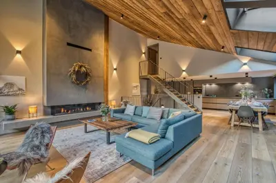 a living room with a blue couch and a table at Chalet Rytola, modern & central chalet in Chamonix in Chamonix-Mont-Blanc