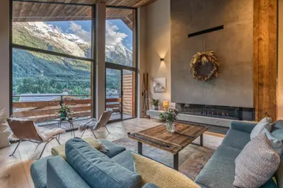 a living room with a blue couch and a fireplace at Chalet Rytola, modern & central chalet in Chamonix in Chamonix-Mont-Blanc