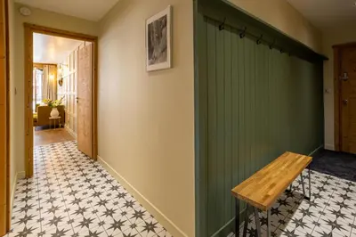 a hallway with a green wall and a wooden bench at Concordia 7 Apartment - Chamonix All Year in Chamonix-Mont-Blanc