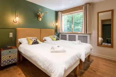 two beds in a room with green walls at Concordia 7 Apartment - Chamonix All Year in Chamonix-Mont-Blanc