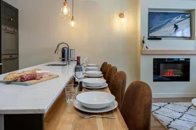 a kitchen with a table with chairs and a fireplace at Concordia 7 Apartment - Chamonix All Year in Chamonix-Mont-Blanc