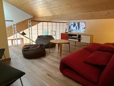 a living room with a red couch and a tv at Duplex Moderne au Centre avec Balcon, 6 Pers. - FR-1-629-13 in Samoëns