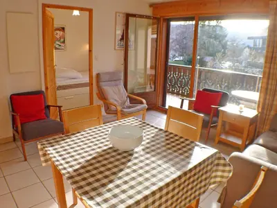 a room with a table and chairs and a balcony at Spacieux appartement 4 pièces avec WIFI, animaux acceptés, parking - FR-1-629-14 in Samoëns