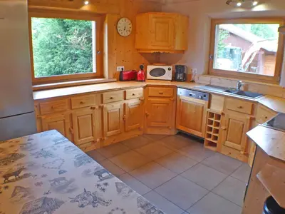 a kitchen with wooden cabinets and two windows at Chalet spacieux 12 pers, animaux admis, parking, Wi-Fi - FR-1-629-1 in Samoëns