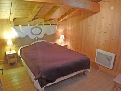 a bedroom with a large bed in a wooden room at Chalet spacieux 12 pers, animaux admis, parking, Wi-Fi - FR-1-629-1 in Samoëns