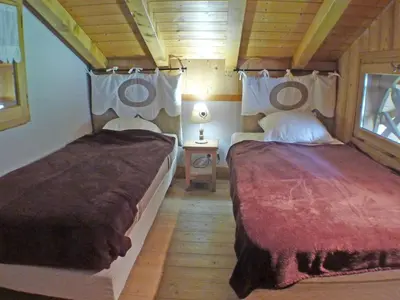 a bedroom with two beds in a wooden cabin at Chalet spacieux 12 pers, animaux admis, parking, Wi-Fi - FR-1-629-1 in Samoëns