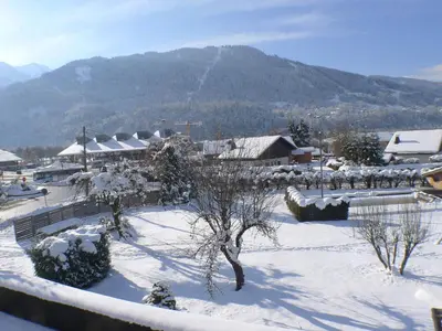 a snow covered village with a mountain in the background at Appartement spacieux 3 pièces avec balcon et garage à Samoëns - FR-1-629-17 in Samoëns