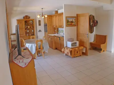 a kitchen with a table and a tv in a room at Appartement spacieux 3 pièces avec balcon et garage à Samoëns - FR-1-629-17 in Samoëns