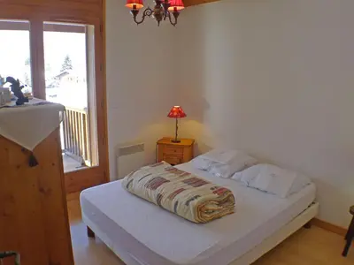 a bedroom with a bed and a window and a lamp at Appartement spacieux 3 pièces avec balcon et garage à Samoëns - FR-1-629-17 in Samoëns