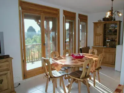 a dining room with a wooden table and chairs at Appartement spacieux 3 pièces avec balcon et garage à Samoëns - FR-1-629-17 in Samoëns