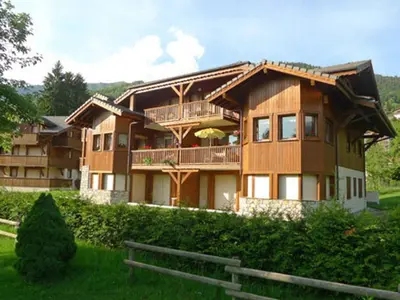 a large wooden house with a fence in front of it at Appartement spacieux 3 pièces avec balcon et garage à Samoëns - FR-1-629-17 in Samoëns