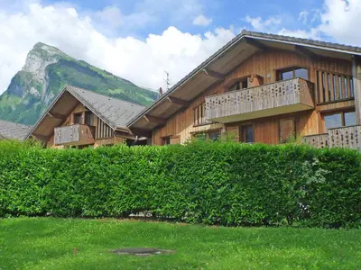 a large wooden house with a mountain in the background at Grand T3 avec cabine - 6 à 8 pers. - Samoëns - FR-1-629-4 in Samoëns